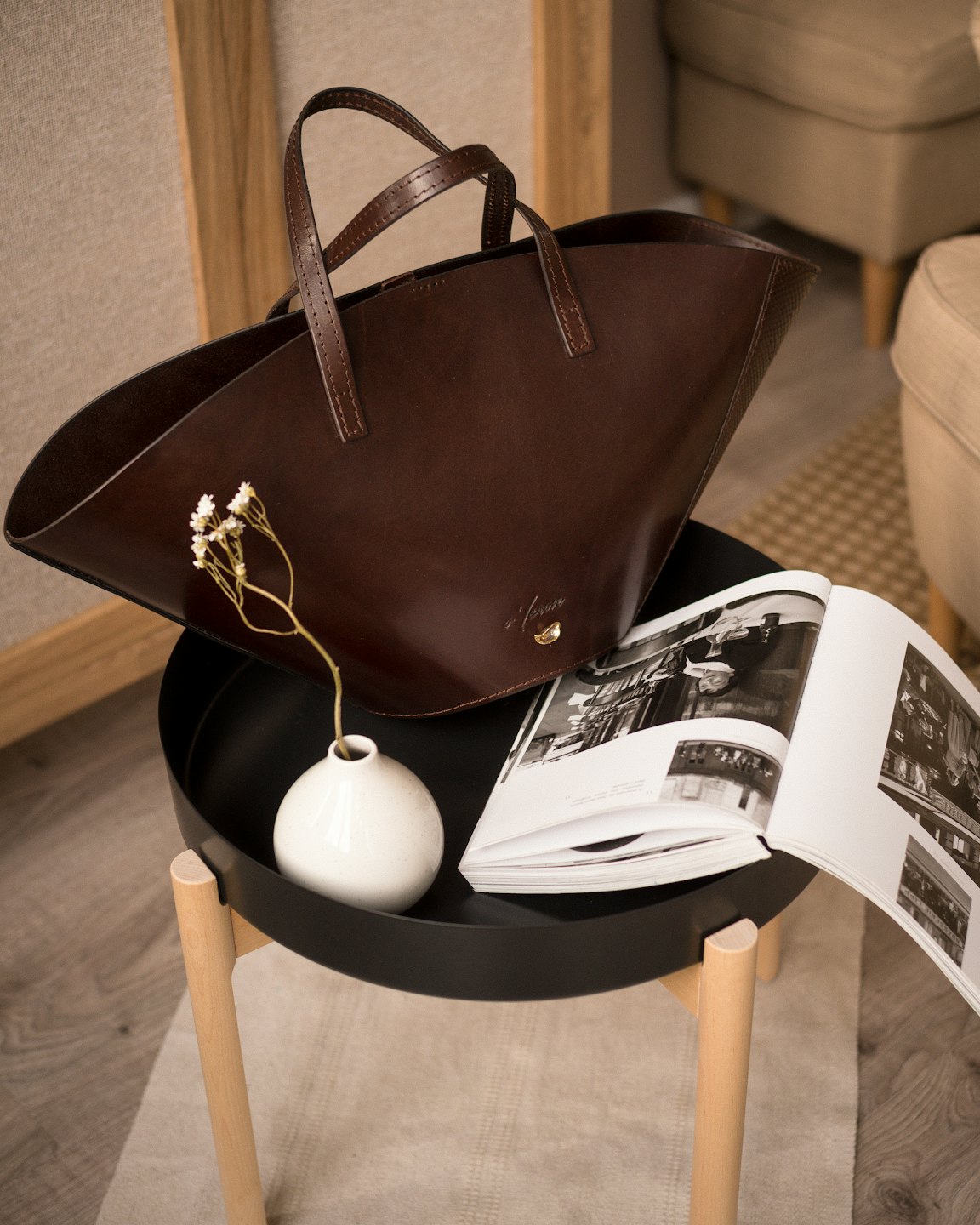 Dark brown leather tote bag on a side table.